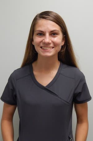Hannah in dark gray scrubs.